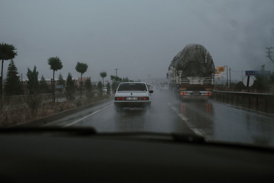 Vehicles driving on a wet highway during rainfall, showcasing road transportation challenges.